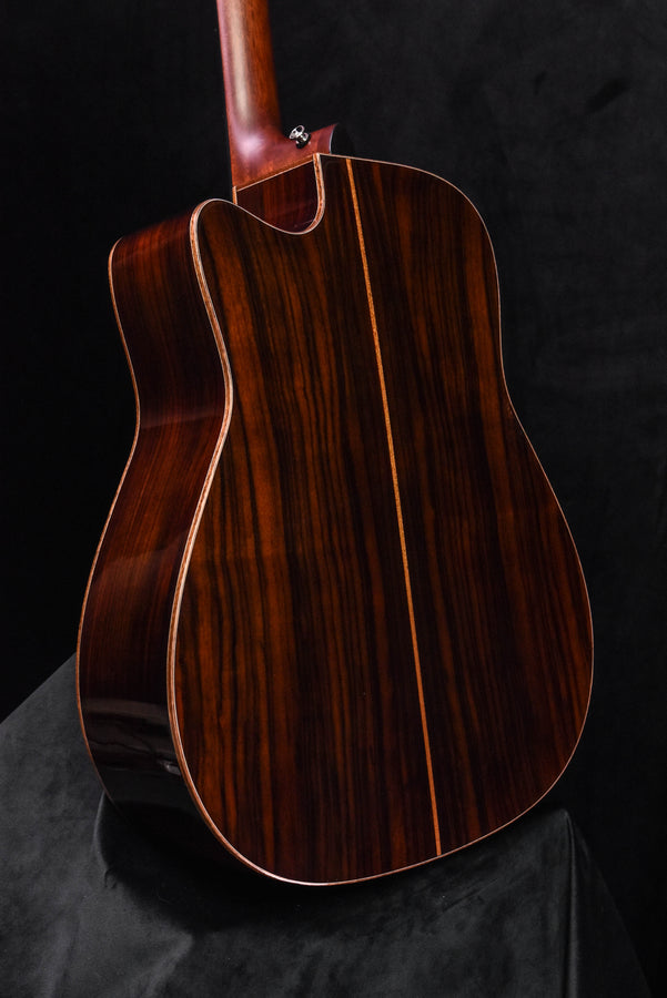 Acoustic-electric guitar body in dark wood finish, bridge and sound hole visible