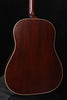 Used acoustic guitar back view, glossy dark brown body with gold binding