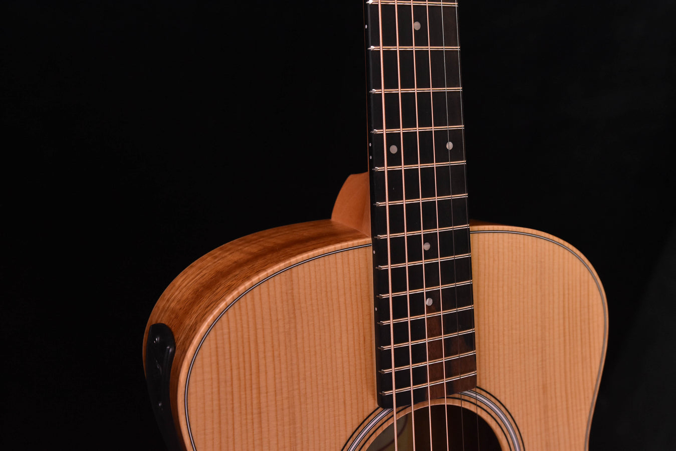 Acoustic guitar close-up: carved fretboard, body edge, round soundhole