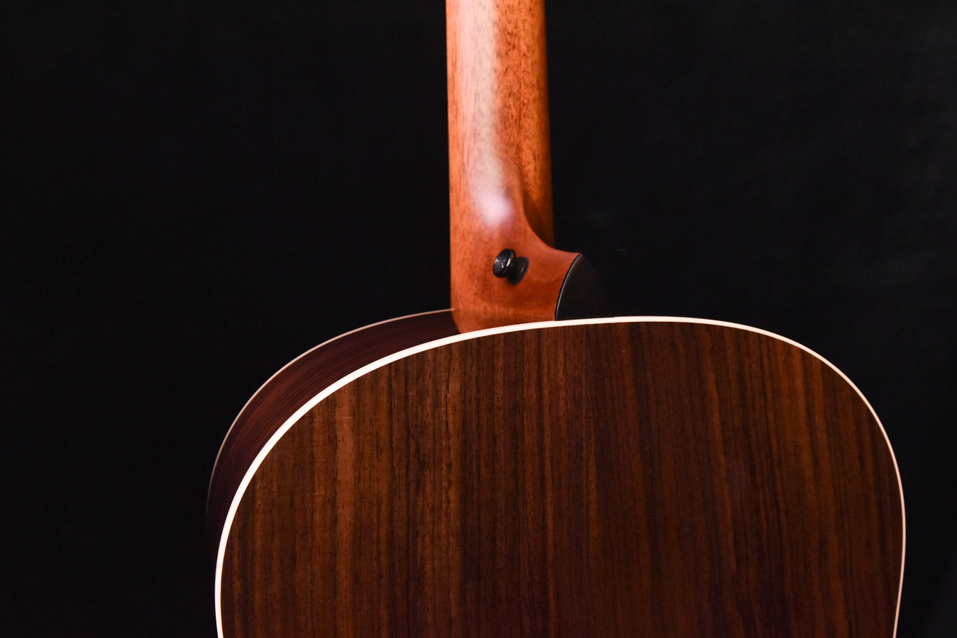Acoustic guitar upper back near neck joint with dark wood grain