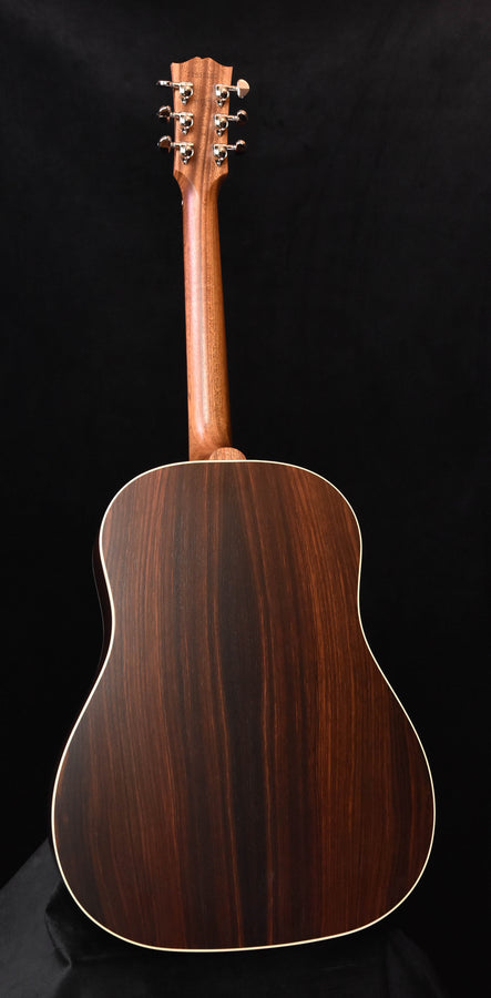 Brown wood acoustic guitar back with gold binding edge, full rear view