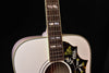 Neck and upper bout of Alpine White Gloss acoustic guitar with hummingbird pickguard