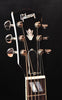 Gibson acoustic guitar headstock with chrome tuners and logo