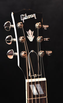 gibson acoustic guitar headstock with chrome tuners and logo