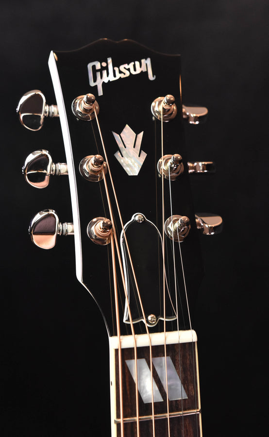 Gibson acoustic guitar headstock with chrome tuners and logo