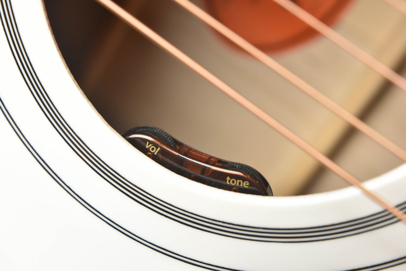 Rosette close-up with black Volume and Tone markings near the sound hole
