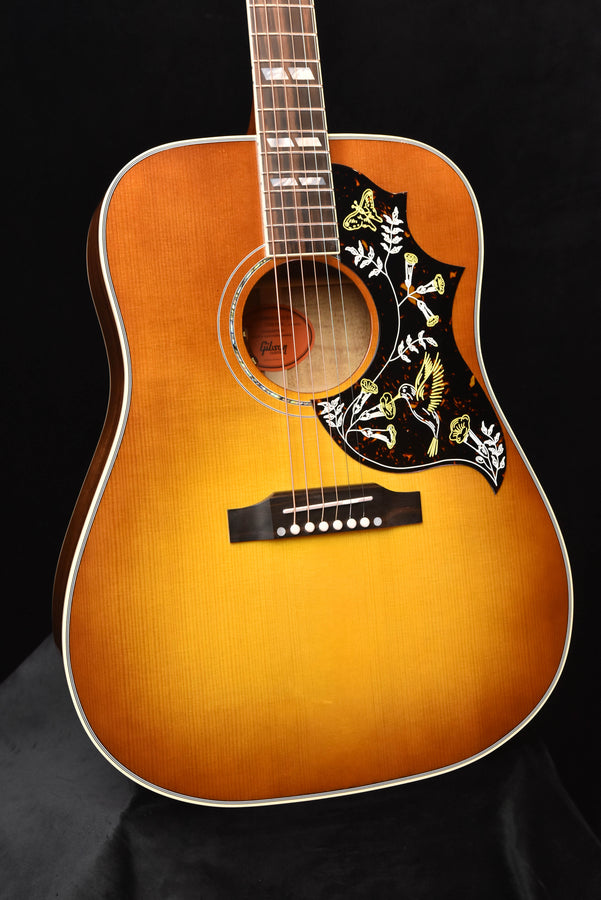 Acoustic guitar front view: sunburst finish, soundhole rosette, hummingbird pickguard
