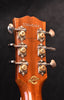 Acoustic guitar headstock close-up with tuning machines and serial label