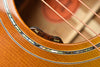 Acoustic guitar side view showing “vol” and “tone” control knobs near soundhole edge