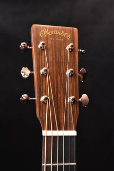 martin acoustic guitar headstock with gold logo and tuning pegs