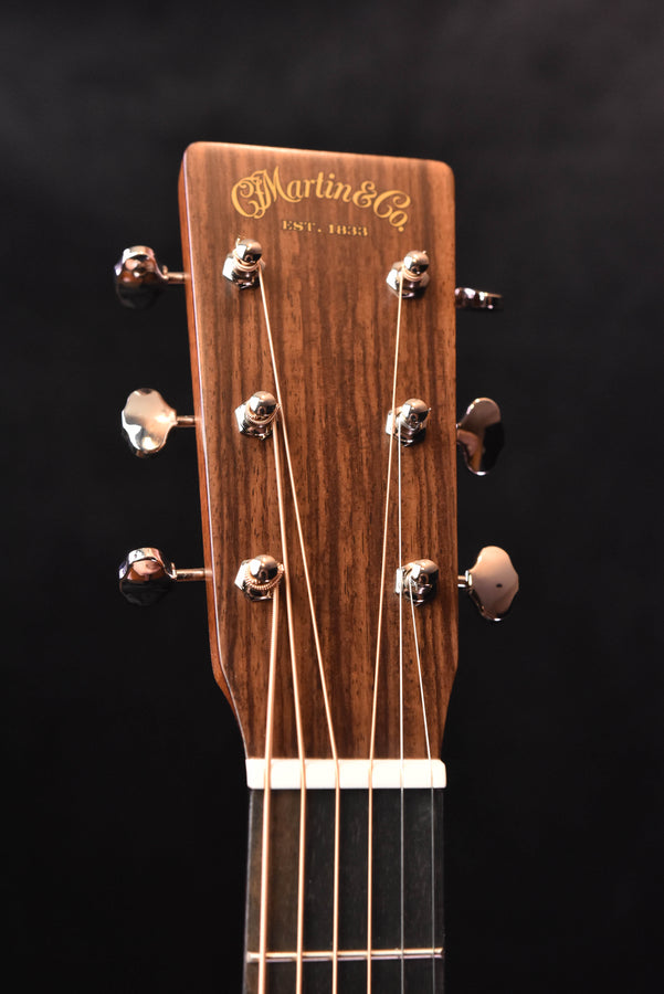 Martin acoustic guitar headstock with gold logo and tuning pegs
