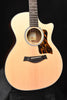 Acoustic-electric guitar front view with natural top, tort-style pickguard, and bridge pins