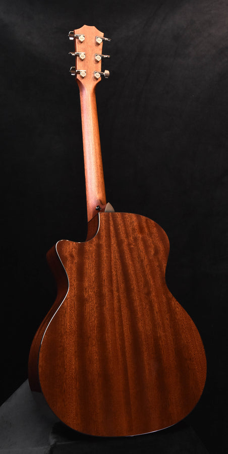 Acoustic-electric guitar with warm brown finish and headstock facing upward