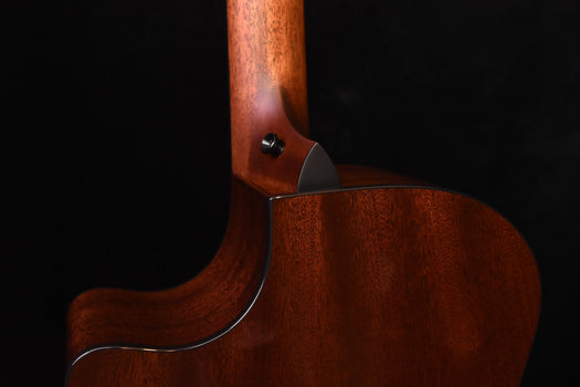 side view of warm brown guitar body with neck joint and cream-colored binding