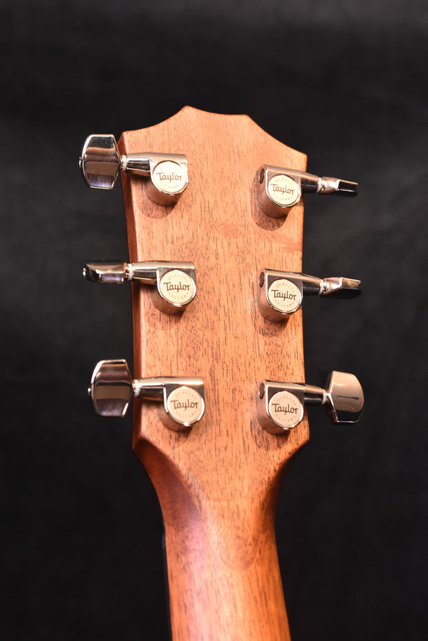 Headstock front with Taylor tuning machines and black tuning pegs