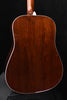 Close-up of acoustic guitar back with dark wood grain and white edge binding