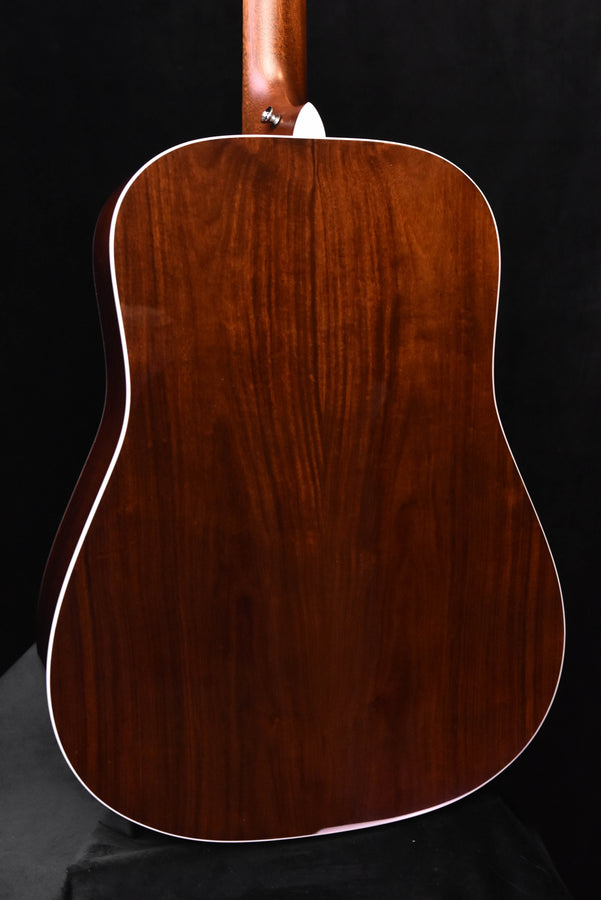 Close-up of acoustic guitar back with dark wood grain and white edge binding
