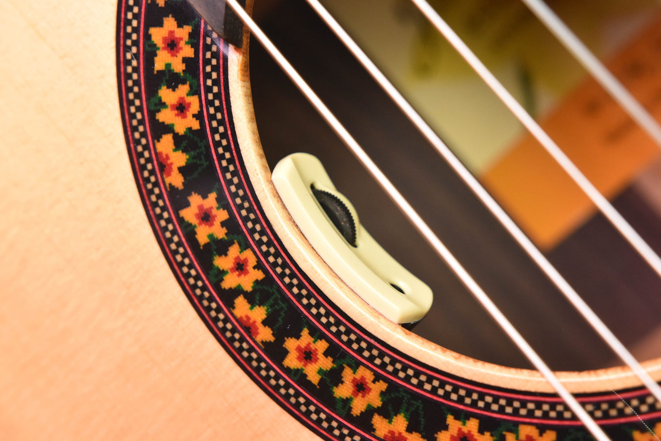 Close-up of decorative rosette and soundhole pickup with visible pickup grille