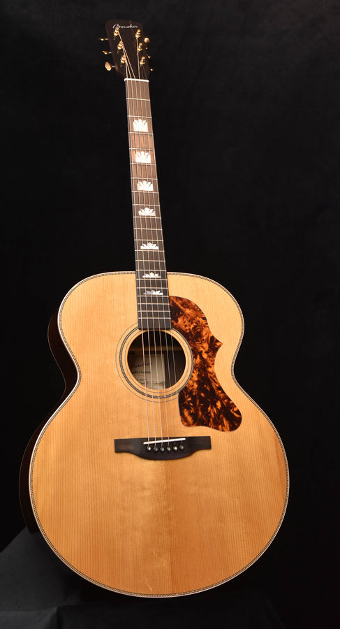 Jumbo acoustic guitar with natural finish, tortoise-pattern pickguard, black bridge