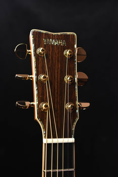 yamaha acoustic guitar headstock with tuning pegs and yamaha logo