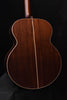 Jumbo acoustic guitar back close-up showing dark wood grain and center seam