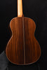 Classical guitar back close-up showing center seam and curved body outline.
