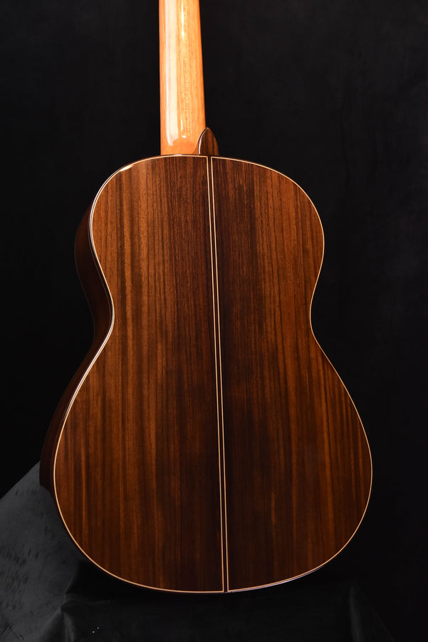 Classical guitar back close-up showing center seam and curved body outline.