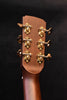 Jumbo acoustic guitar headstock close-up with gold tuners and tuning keys
