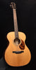Natural-finish acoustic guitar with spruce-style top, round rosette, and dark pickguard