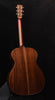 Dark brown acoustic guitar with glossy finish and visible headstock tuning pegs