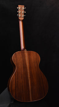 dark brown acoustic guitar with glossy finish and visible headstock tuning pegs