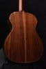 Back view of dark brown acoustic guitar with vertical wood grain pattern