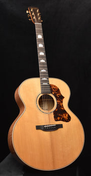 natural wood acoustic guitar with tortoiseshell-style pickguard and sound hole rosette