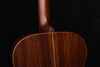 Close-up of dark brown acoustic guitar back with curved body contour