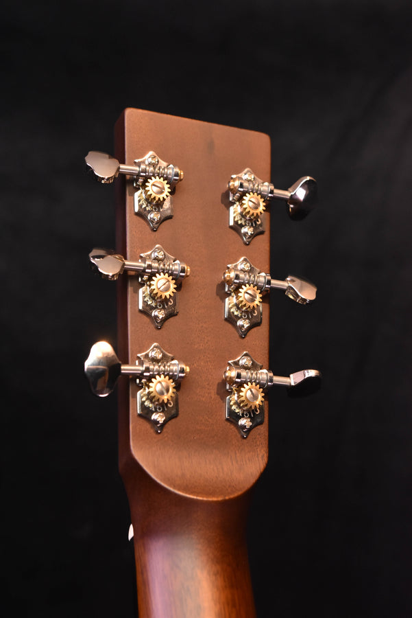 Acoustic guitar headstock with six tuning pegs and ornate metal tuning gears