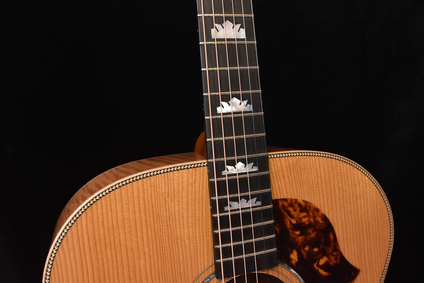 Close-up of acoustic guitar soundboard with bridge and rosette view