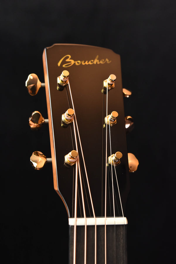 Acoustic guitar headstock with gold tuners and engraved Boucher brand