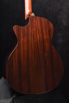 dark wood acoustic guitar back view with prominent grain and rounded shoulder