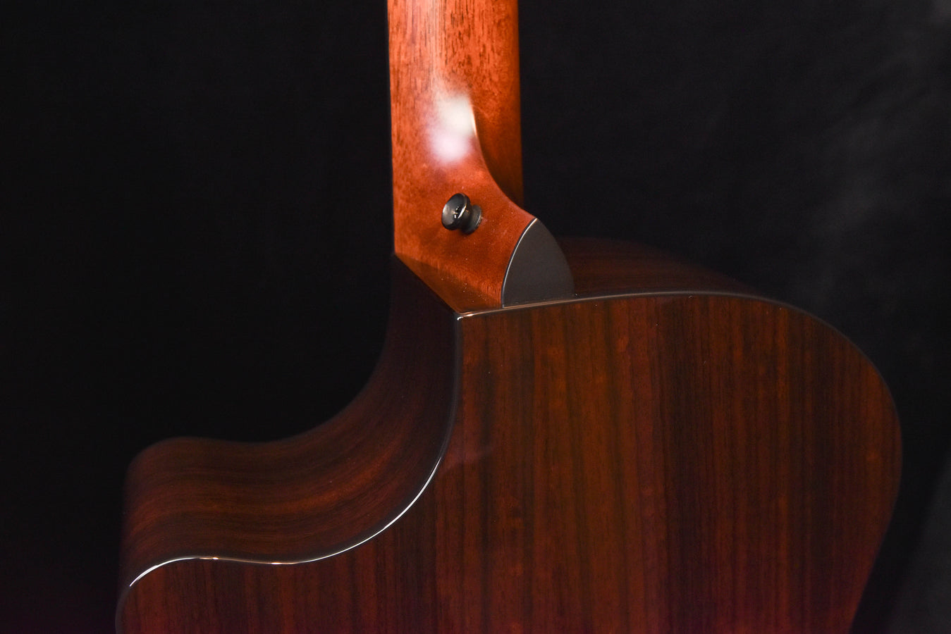 Acoustic guitar side body and neck joint with glossy dark wood finish