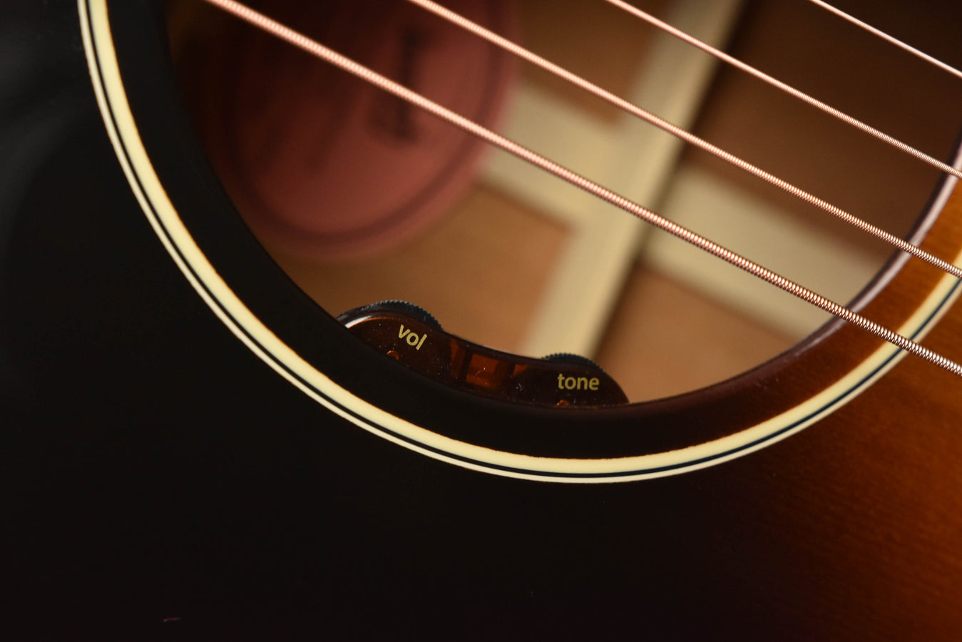 Acoustic guitar soundhole with volume and tone control labels