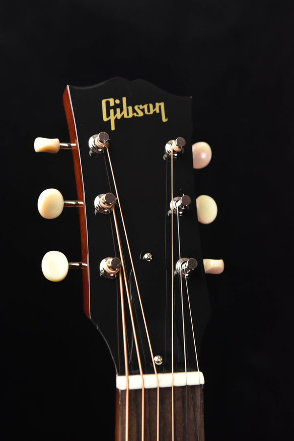 Gibson acoustic guitar headstock with gold logo and chrome tuning machines