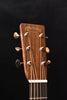Martin headstock with logo and tuning pegs on dark wood acoustic guitar