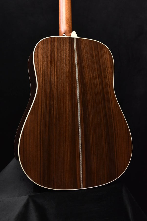 Full view of acoustic guitar back with natural wood finish and binding outline