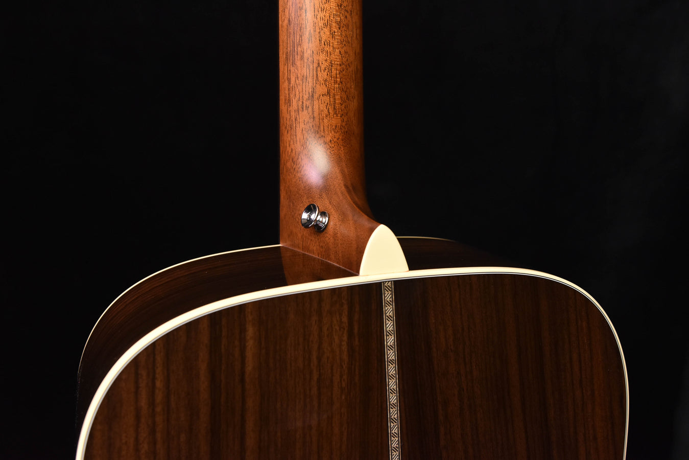 Acoustic guitar neck joint area with strap button and dark wood top binding