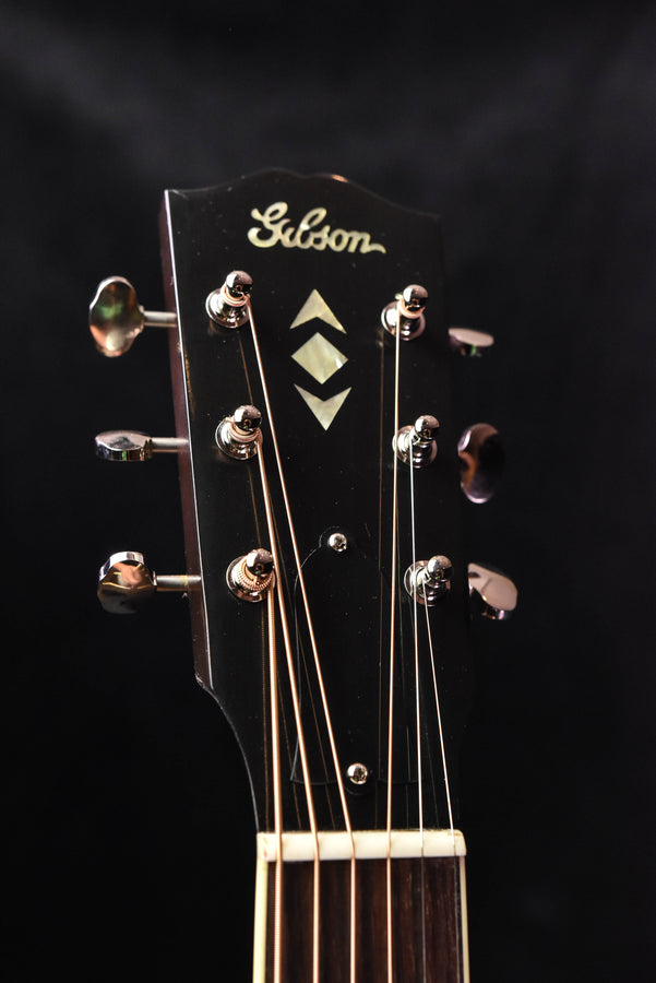 Gibson headstock with ornate tuning machines and diamond inlay logo