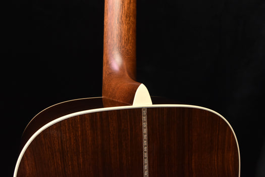 acoustic guitar top edge close-up with cream binding and wood finish