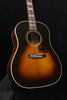 Gibson acoustic guitar front view with sound hole, tortoiseshell pickguard, and rosewood bridge