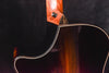Acoustic guitar neck-body joint with wood grain and side binding detail.