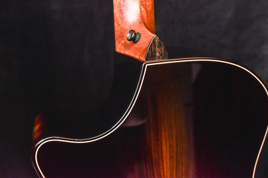 acoustic guitar neck-body joint with wood grain and side binding detail.