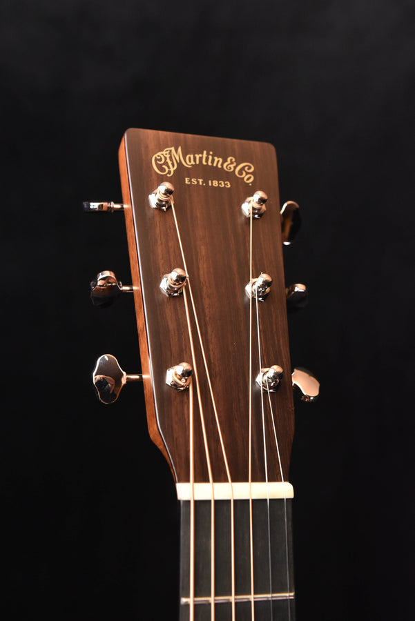 Martin acoustic guitar headstock with tuning pegs and engraved brand logo